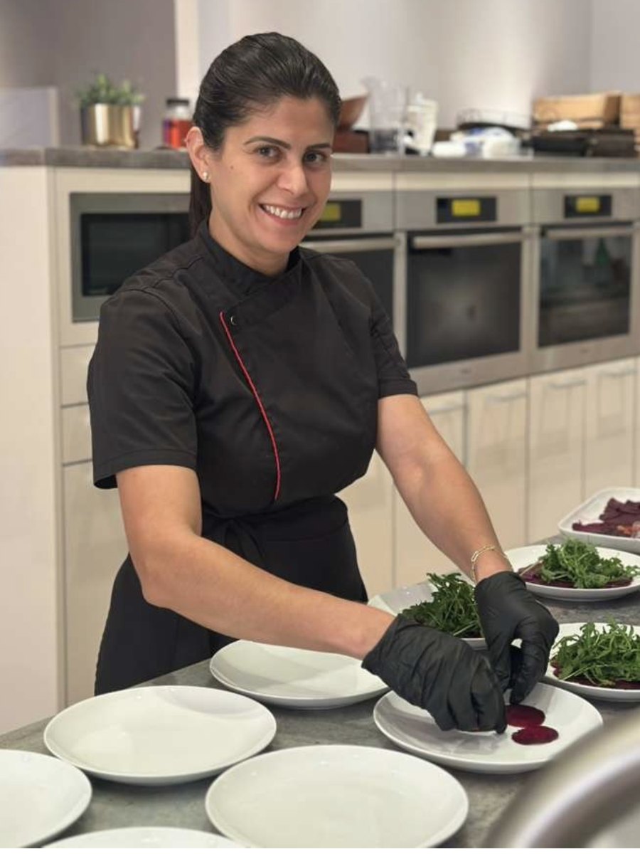 Chef Jackie Wheeler plating salads in a client kitchen